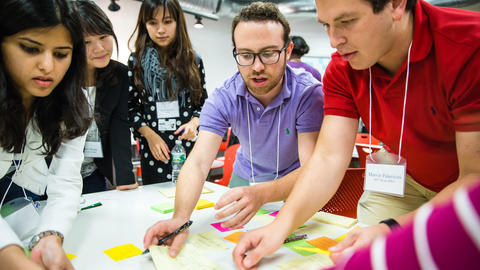 A classroom of students working collaboratively with post-it notes