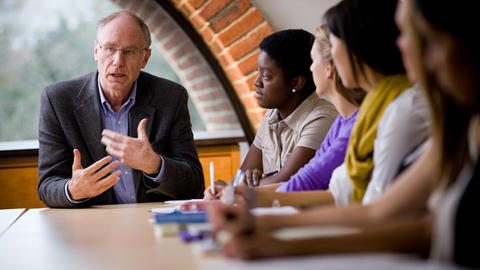 A person presenting to a group of students