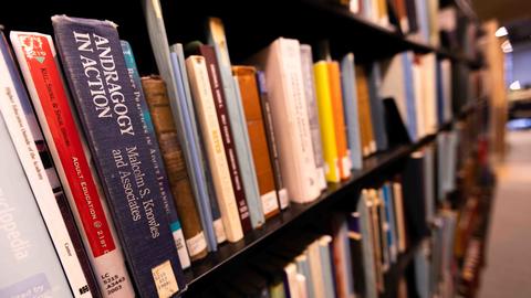 a sequence of books on a book shelf in a library