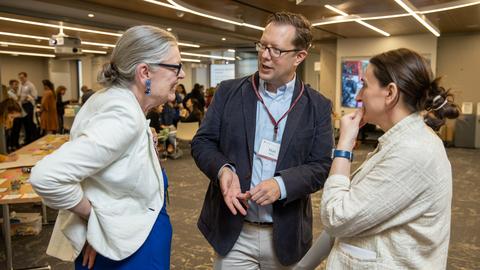 Three people sharing in a conversation in a lively environment