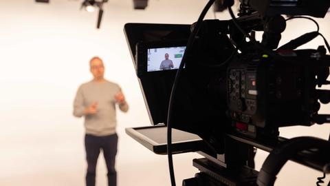 Person in a studio presenting to a camera