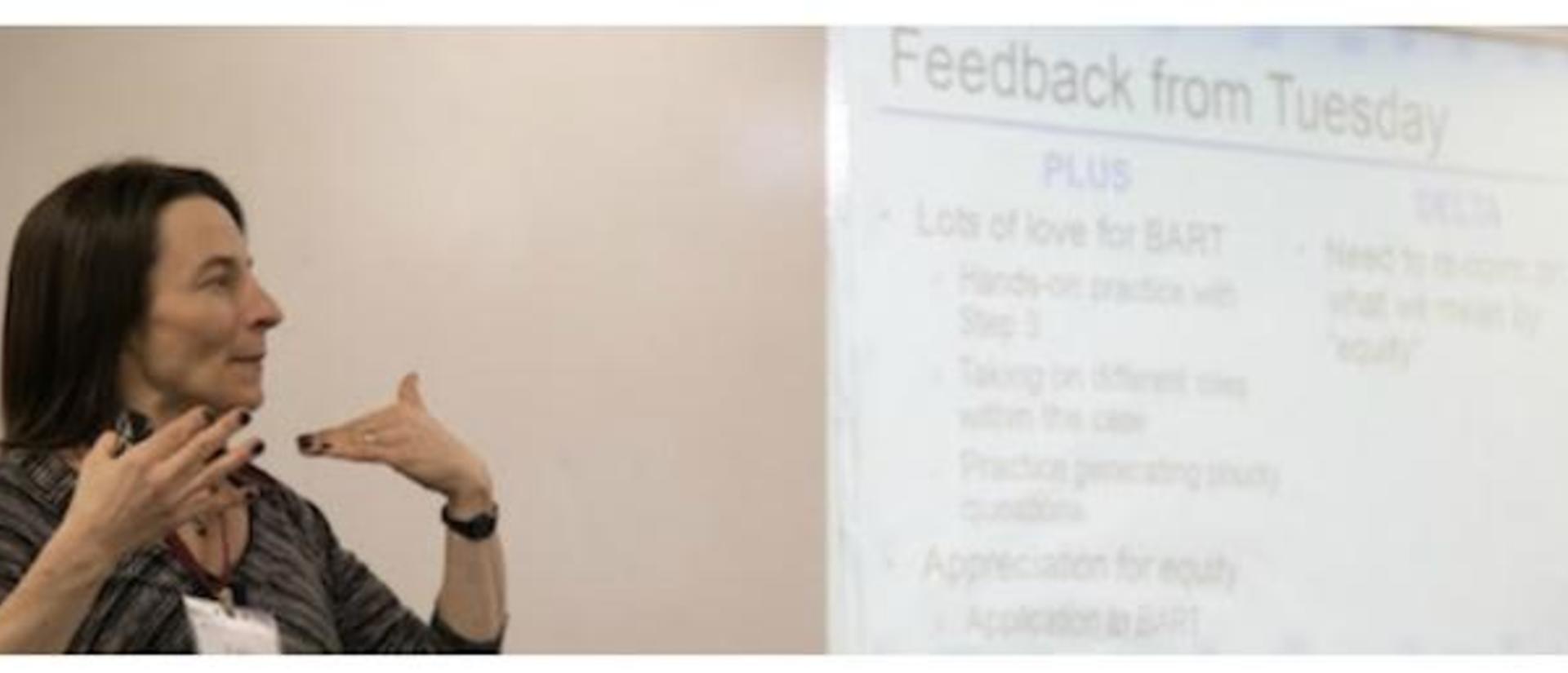 Person presenting in front of a projector