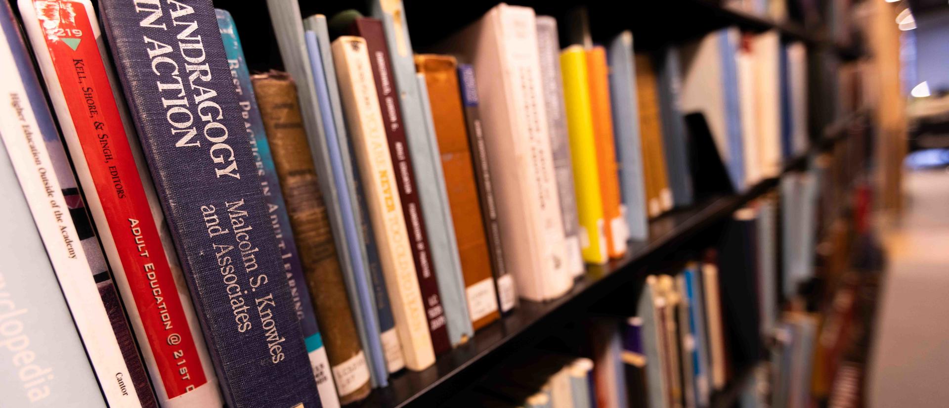 a sequence of books on a book shelf in a library